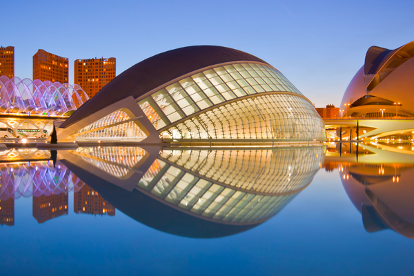 Futuristisches Gebäude der Ciudad de las Artes y las Ciencias in Valencia, Spanien, bei Sonnenuntergang mit Spiegelung im Wasser.